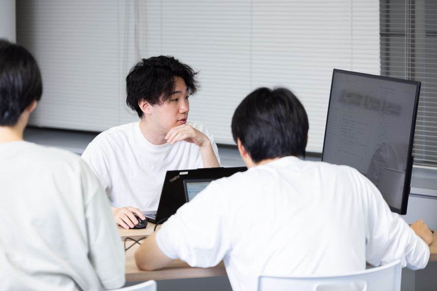 デスクで相談するメンバー